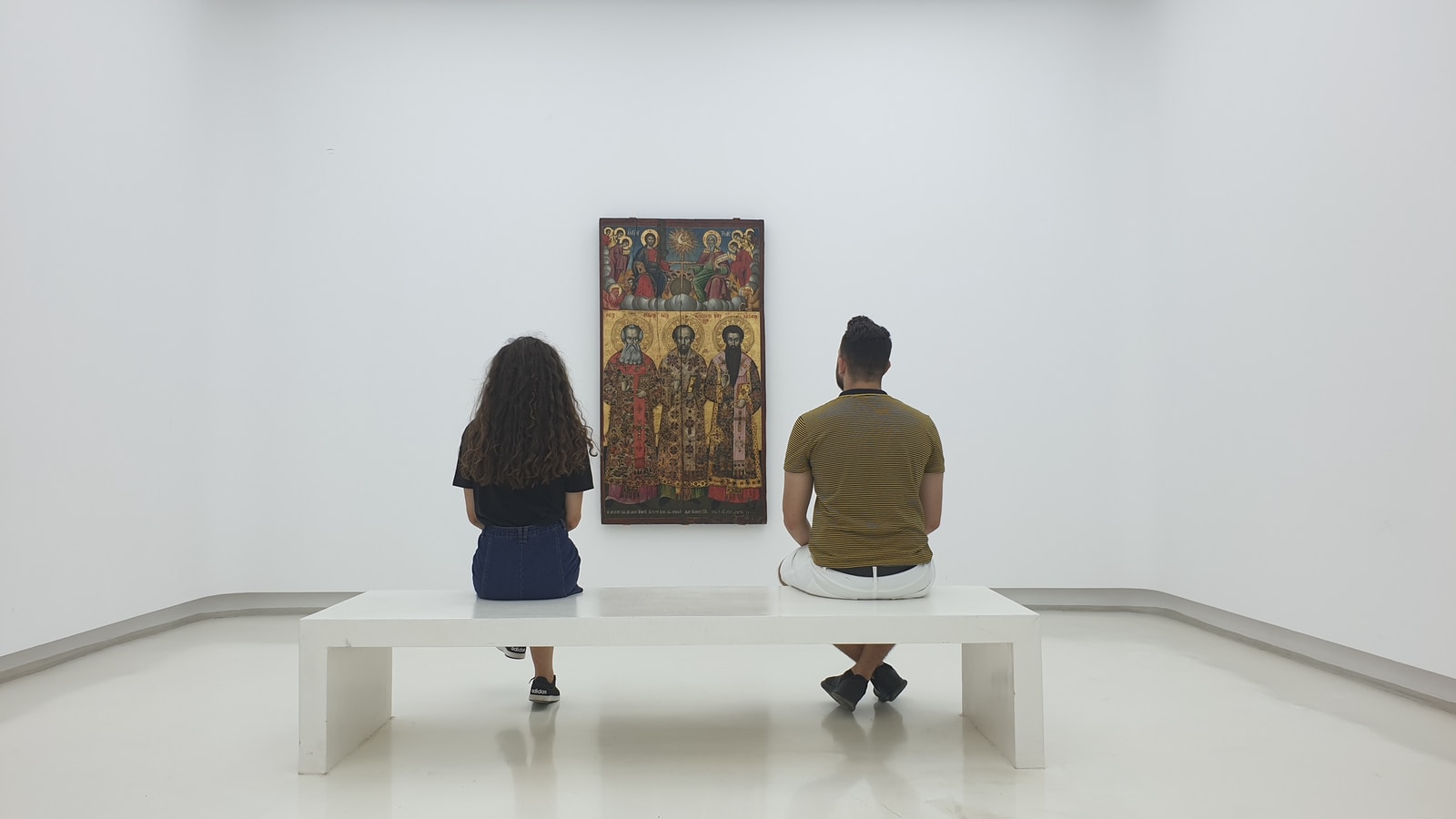 two persons sitting near each other and looking at artwork
